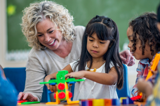 Child plays with toys while adult supports